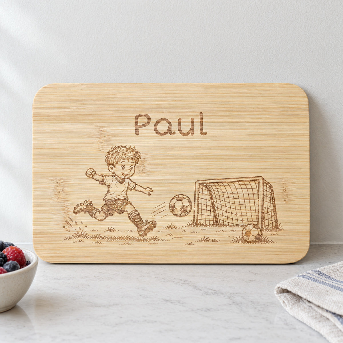 Personalisiertes Frühstücksbrettchen aus Bambus mit Fußball-Gravur und Wunschgravur, vertiefte dunkelbraune Lasergravur, 22 x 14 cm.