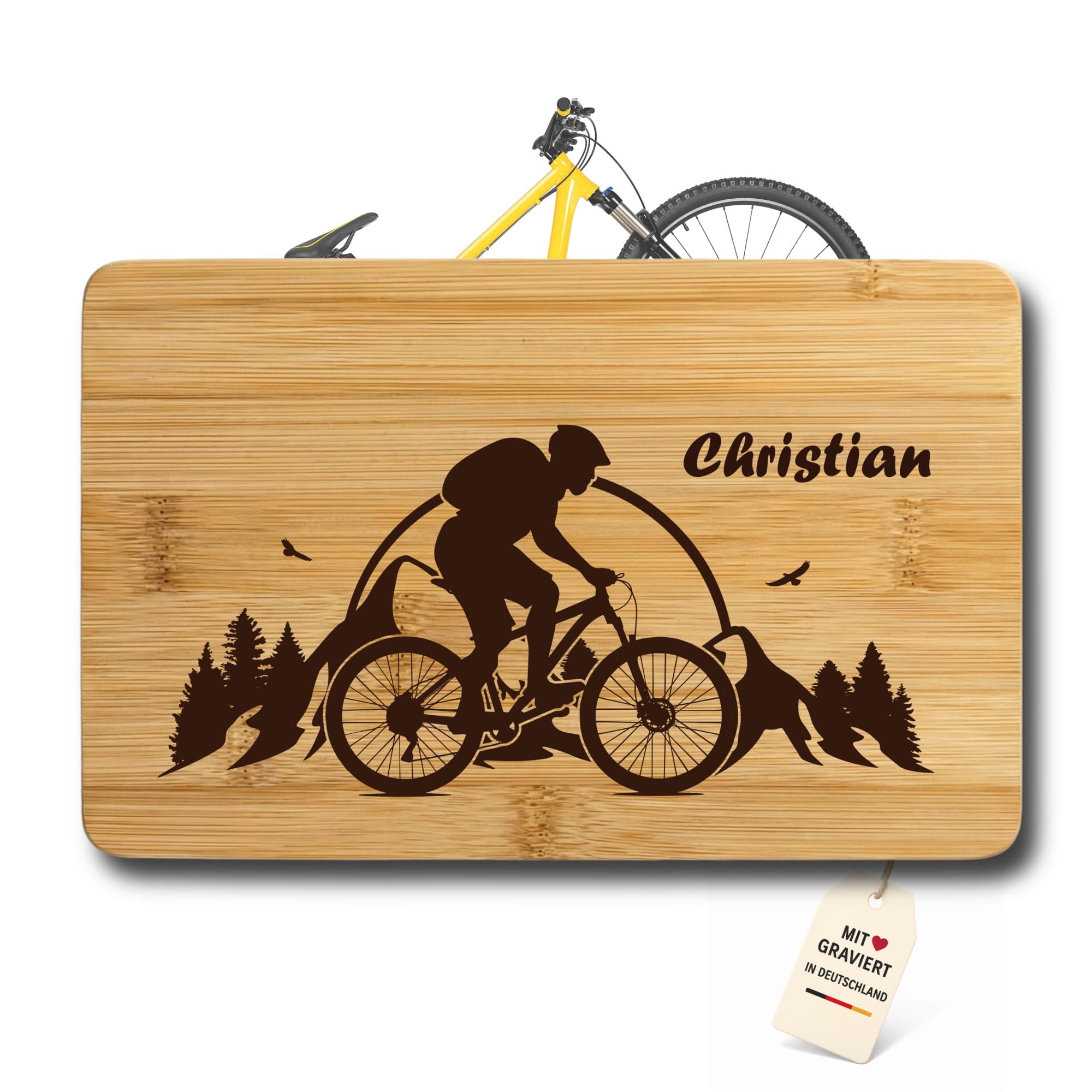 Frühstücksbrettchen aus Bambus mit Mountainbike Gravur, Name Christian und dekorativem Fahrrad im Hintergrund