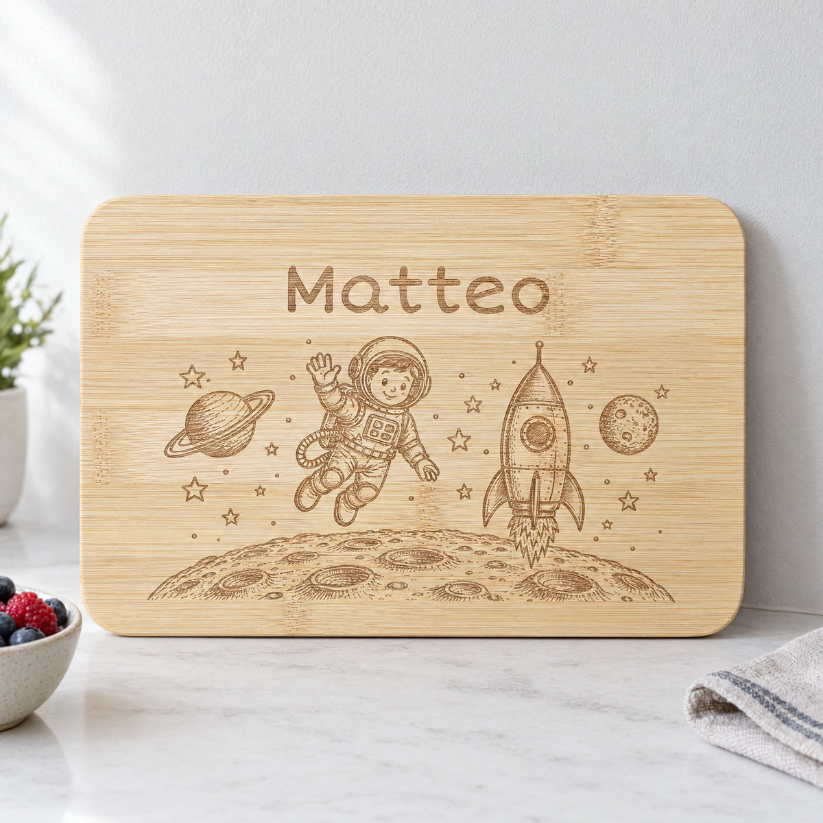 Personalisiertes Frühstücksbrettchen aus Bambus mit Astronaut-Gravur und Wunschgravur, vertiefte dunkelbraune Lasergravur, 22 x 14 cm.
