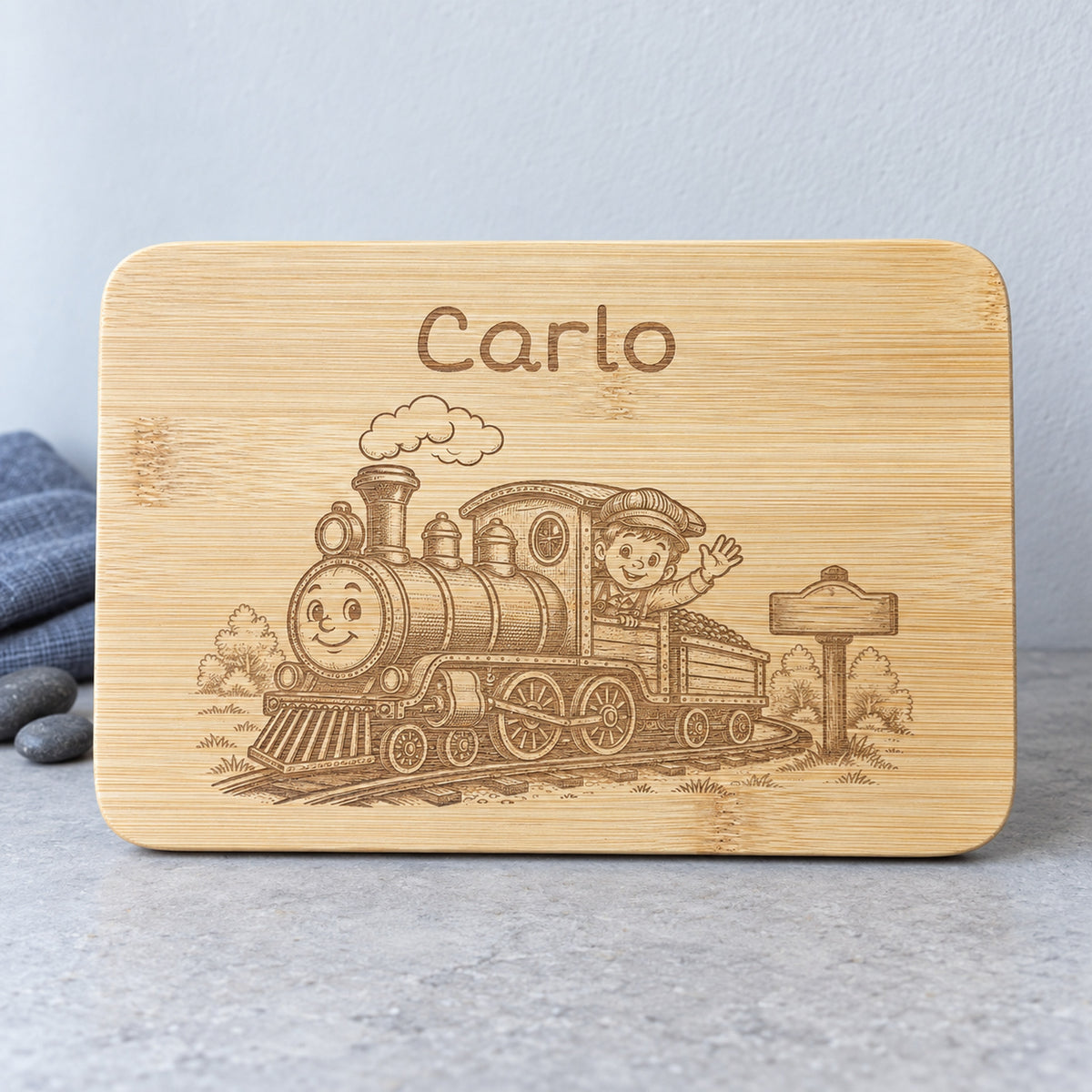 Personalisiertes Frühstücksbrettchen aus Bambus mit Lokomotive-Gravur und Wunschgravur, vertiefte dunkelbraune Lasergravur, 22 x 14 cm.