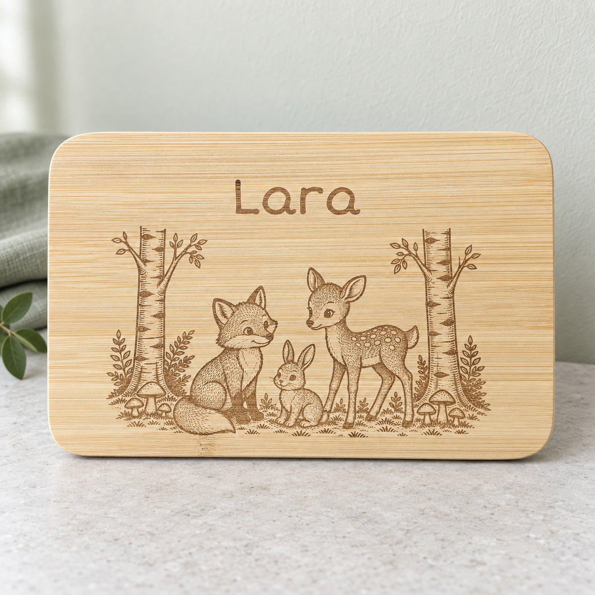 Personalisiertes Frühstücksbrettchen aus Bambus mit Waldtiere-Gravur und Wunschgravur, vertiefte dunkelbraune Lasergravur, 22 x 14 cm.