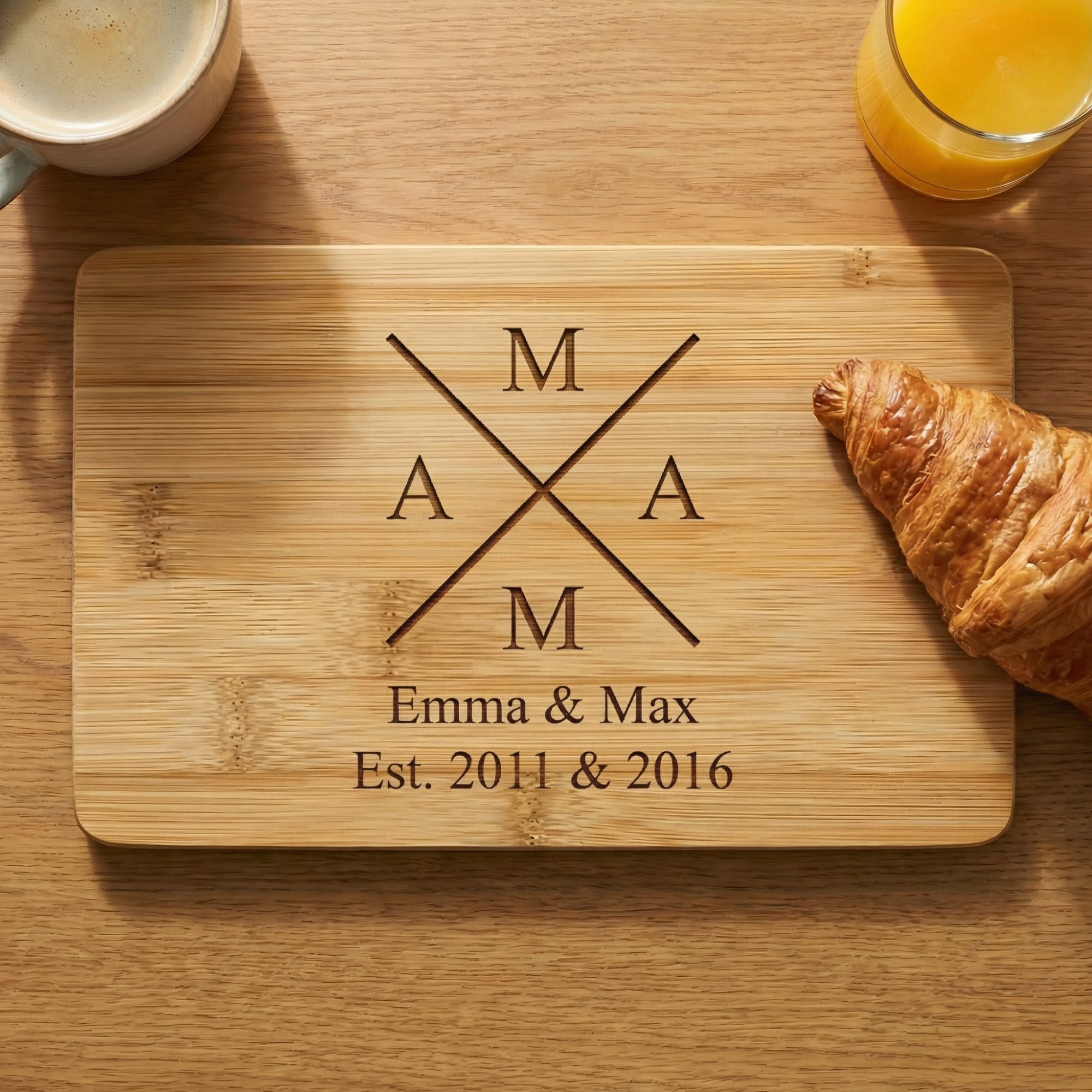 Personalisiertes Bambus Frühstücksbrettchen mit Mama X Gravur und Wunschtext auf Holztisch mit Kaffee und Croissant