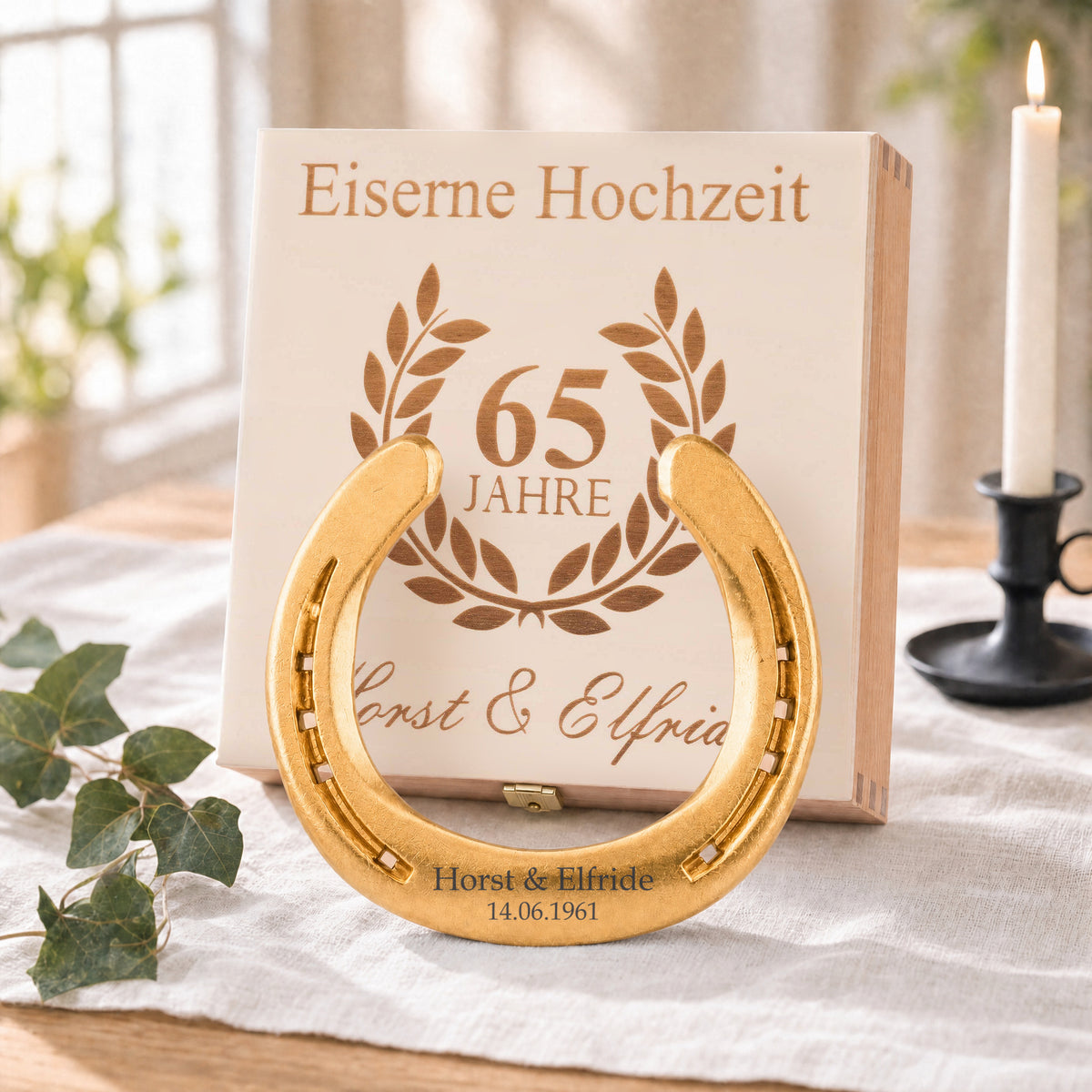 Vergoldetes Glückshufeisen (24 Karat) zur Eisernen Hochzeit mit Namensgravur vor der Holz-Geschenkbox, Deckel graviert mit Lorbeerkranz, 65 Jahre und Namen